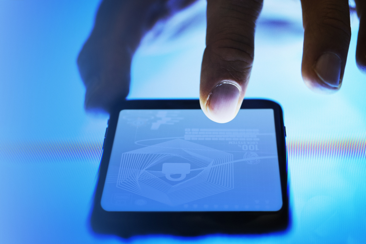 A man touching his phone screen and the screen has an image of a lock on it