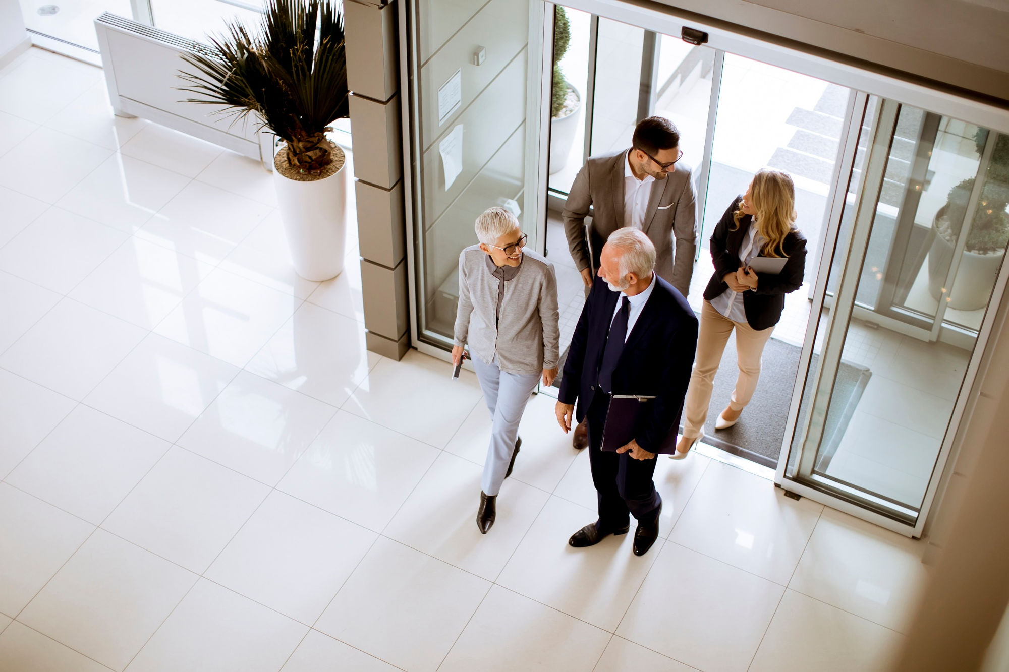 Group walking through an automated door at entrance to a building