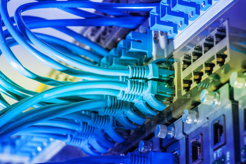 Network cables and hub closeup with fiber optical background