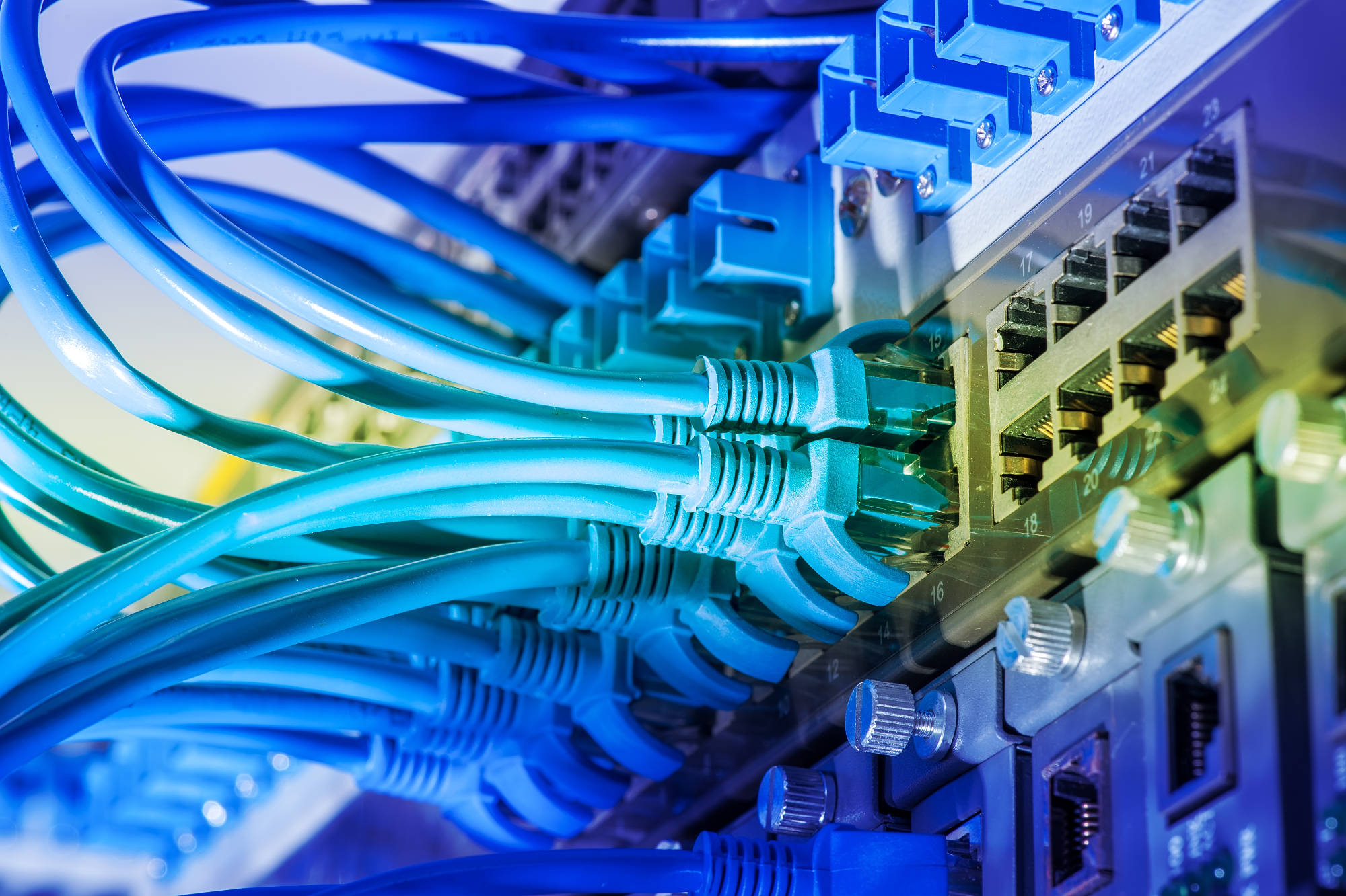 Network cables and hub closeup with fiber optical background