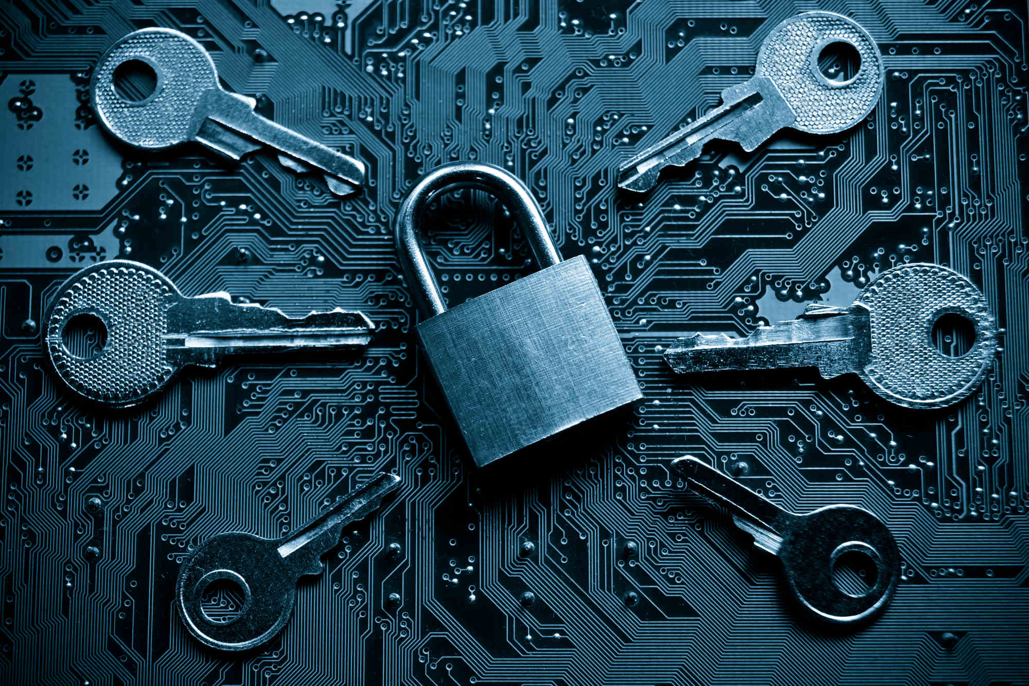 Security lock on a computer circuit board surrounded by keys