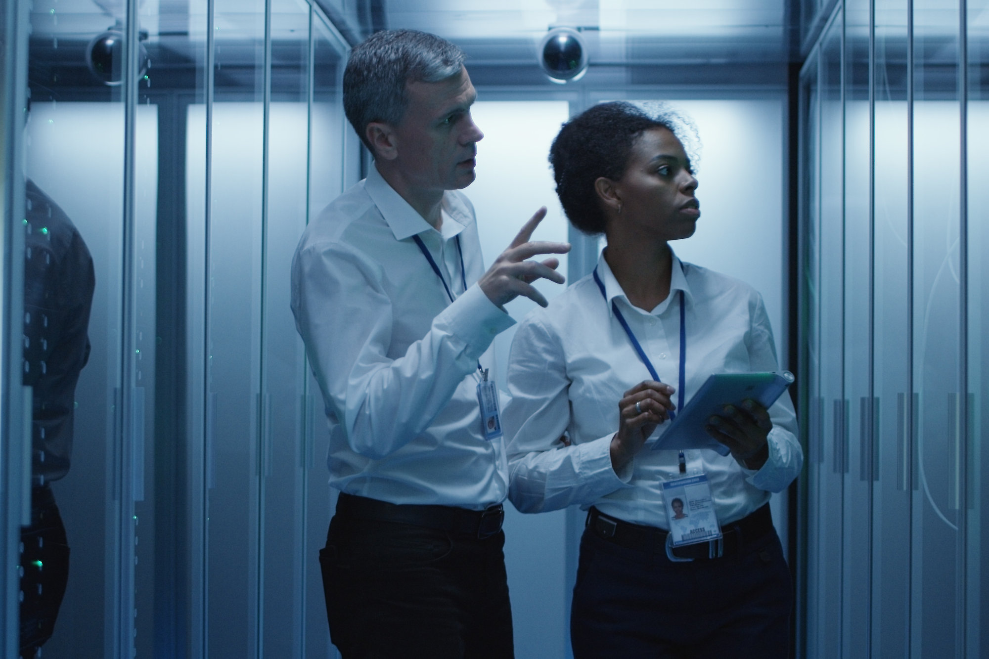 Man and woman in data center diagnosing server hardware
