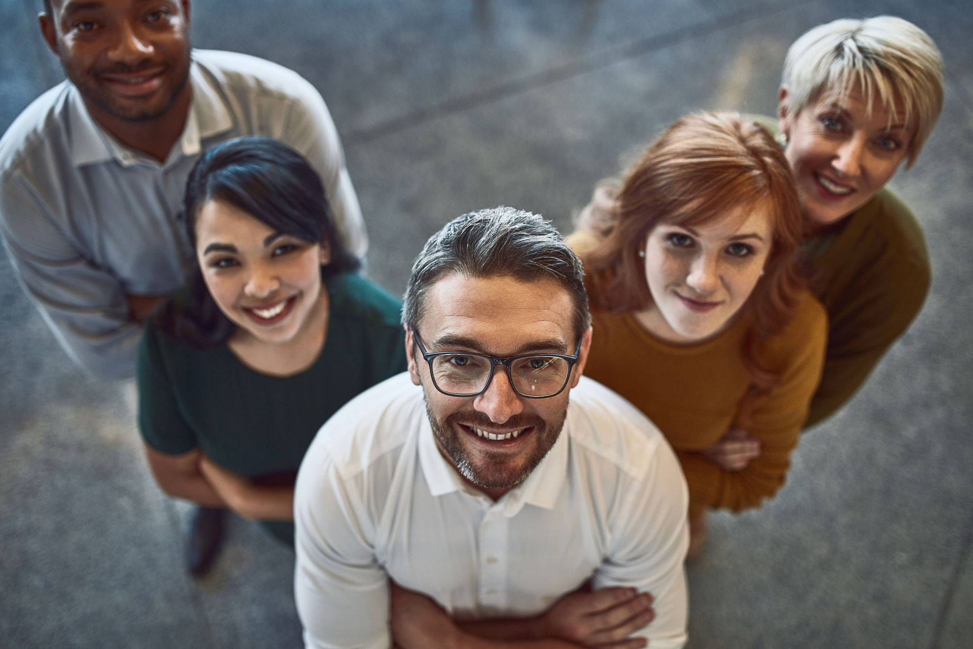 Portrait of a diverse group of workers smiling up towards the camera