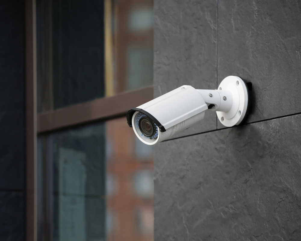 Close-up of a cylindrical security camera on the side of a building